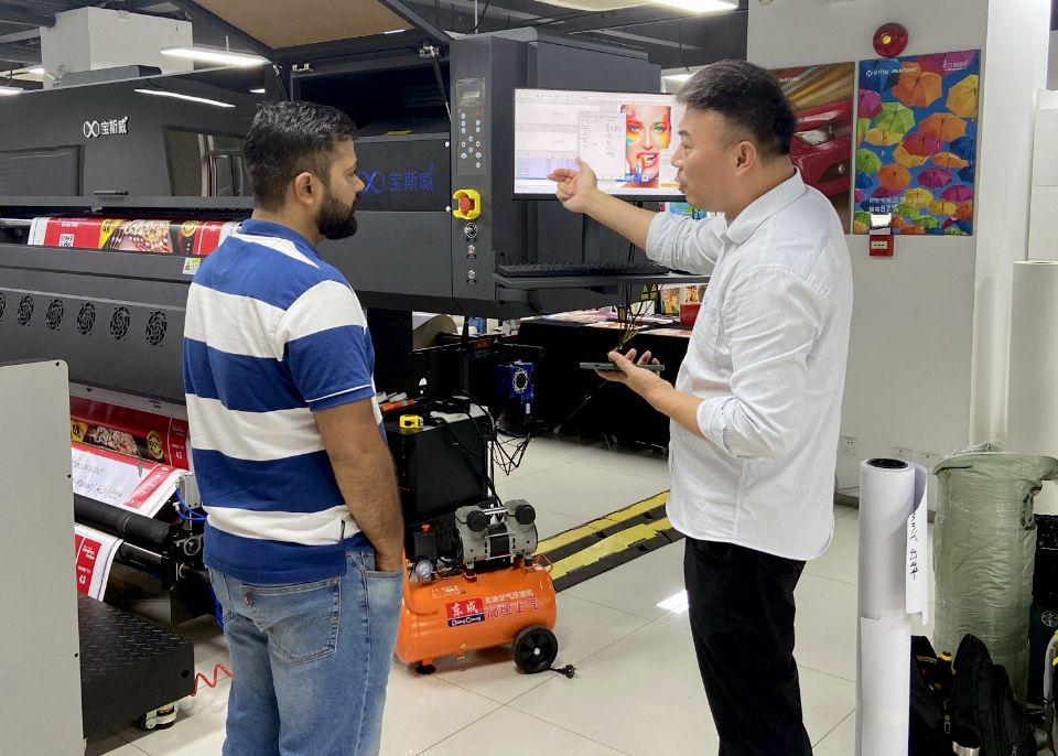 Quản lý Baosiwei hướng dẫn kỹ sư Ấn Độ về cấu hình và cách sử dụng máy in UV trong buổi đào tạo.