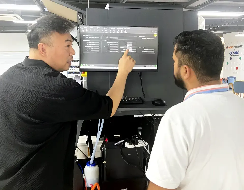 Quản lý Baosiwei hướng dẫn kỹ sư Ấn Độ cách sử dụng phần mềm điều khiển máy in UV trong buổi đào tạo.