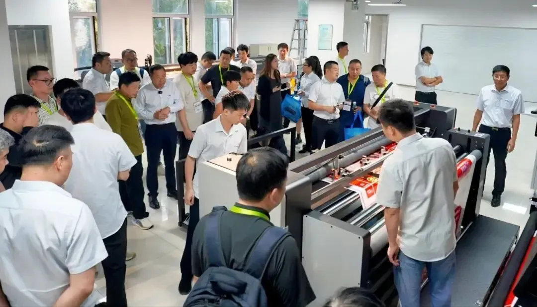 Các lãnh đạo doanh nghiệp bao bì quan sát trình diễn máy in kỹ thuật số 16 đầu Baosiwei in trên giấy tráng, thảo luận sôi nổi và thể hiện sự quan tâm lớn