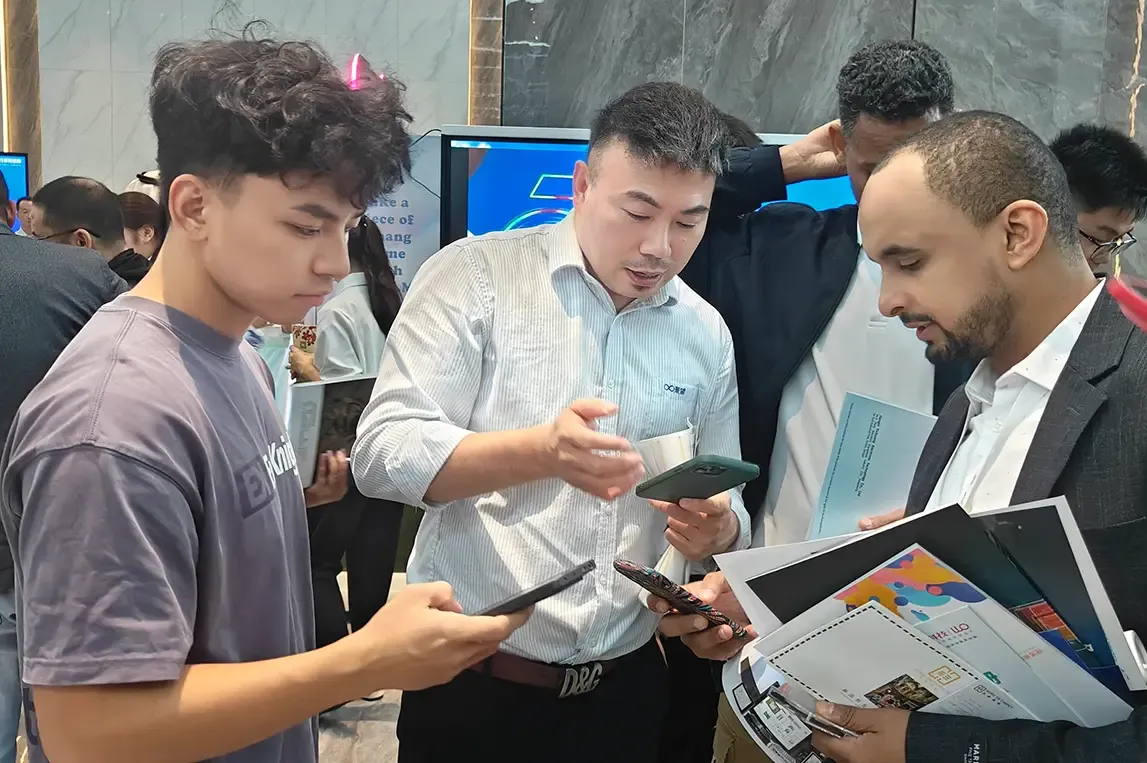 Baosiwei sales staff talking with Saudi business representatives and exchanging contact information during the trade meeting.