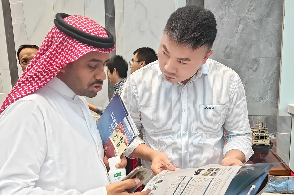 Baosiwei sales representative introducing machine details and answering questions from Saudi buyers during the trade meeting.