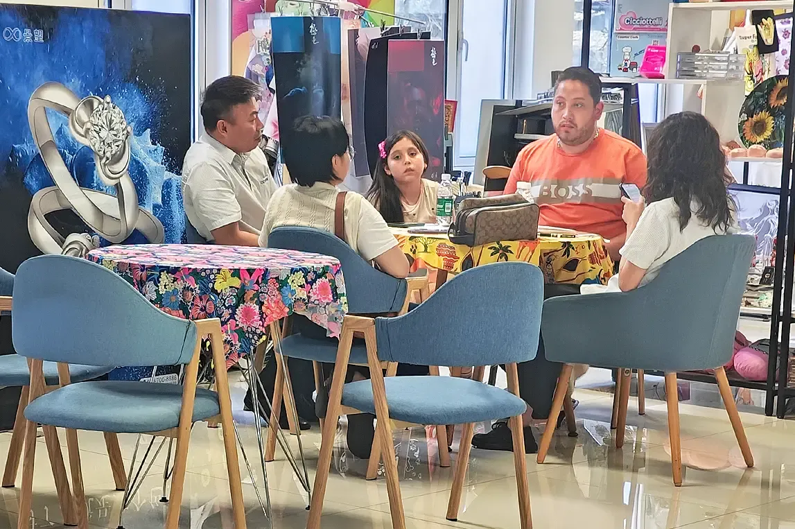 Baosiwei sales representative explaining leather uv printing solutions to customer at showroom